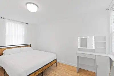 a white bedroom with a bed and a tv at New home, 17 min to NYC, 5 min to MetLife Stadium in Carlstadt