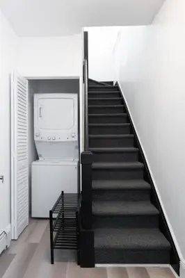 a staircase in a house with a washer and dryer at New home, 17 min to NYC, 5 min to MetLife Stadium in Carlstadt