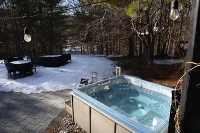 a jacuzzi tub in a yard in the snow at The Vault - Hidden Playroom For Couples - Private Hot Tub - Mountain Views - Riverfront in Barryville