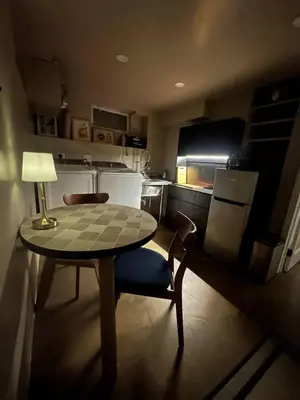 a small kitchen with a table and a chair and a lamp at The Vault - Hidden Playroom For Couples - Private Hot Tub - Mountain Views - Riverfront in Barryville