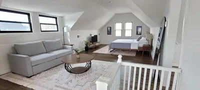 a living room with a couch and a bed at Duplex 15 mins from Time Square! in West New York