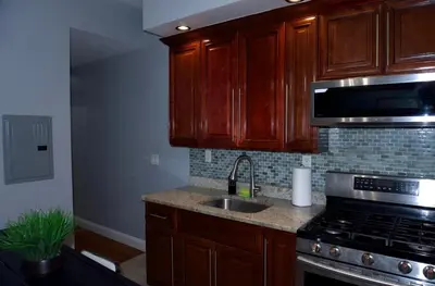 a kitchen with wooden cabinets and a sink and a stove at New York private room 31 in West New York