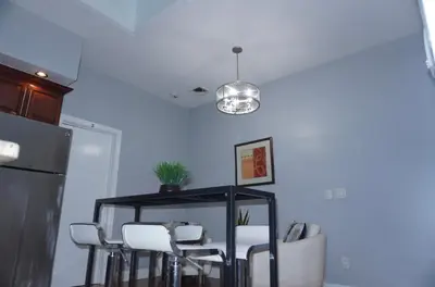a dining room with a table and white chairs at New York private room 31 in West New York