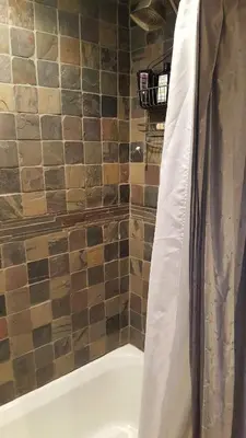 a bathroom with a bath tub with a shower curtain at Catskills Aframe, Water View, Goat Sanctuary in Napanoch