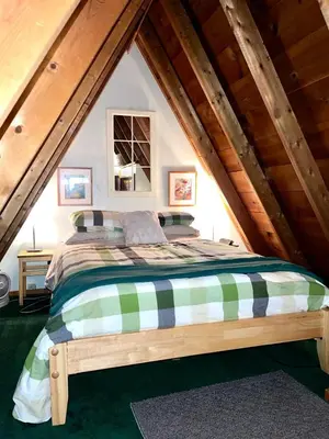 a bedroom with a bed in the attic at Catskills Aframe, Water View, Goat Sanctuary in Napanoch
