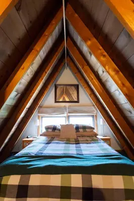 a bedroom with a bed in the attic at Catskills Aframe, Water View, Goat Sanctuary in Napanoch