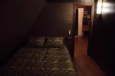 a bedroom with a bed in a dark room at Romantic AFrame Cabin with Firepit, BBQ in Pocono Pines