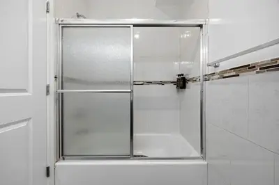 a shower with a glass door in a bathroom at Sleeps 19 • 15ft Celings • Near NYC in Jersey City