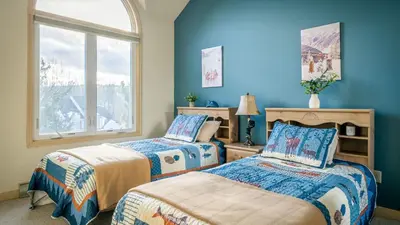 two beds in a room with blue walls at Mountain Laurel Lodge by AvantStay Lake Harmony Retreat • Loft Games Ski Private Club Access in Lake Harmony