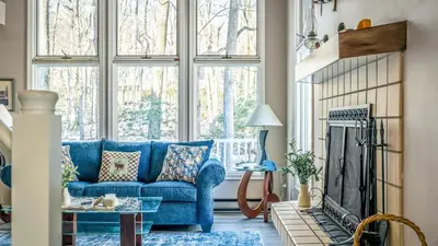 a blue couch in a living room with a fireplace at Mountain Laurel Lodge by AvantStay Lake Harmony Retreat • Loft Games Ski Private Club Access in Lake Harmony