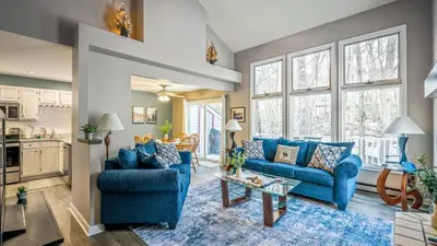 a living room with blue couches and a table at Mountain Laurel Lodge by AvantStay Lake Harmony Retreat • Loft Games Ski Private Club Access in Lake Harmony