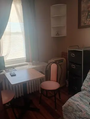 a bedroom with a table and two chairs and a desk at Oakland House Apartments in Phoenixville