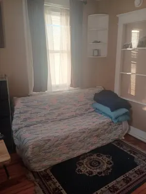 a bedroom with a bed in a room with a window at Oakland House Apartments in Phoenixville