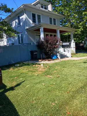 a white house with a fence in the yard at Oakland House Apartments in Phoenixville