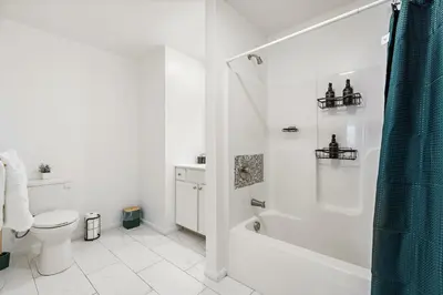 a white bathroom with a shower and a toilet at Urban Haven XL - NYC & Newark with free parking in Newark