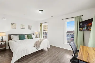 a white bedroom with a bed and a window at Urban Haven XL - NYC & Newark with free parking in Newark