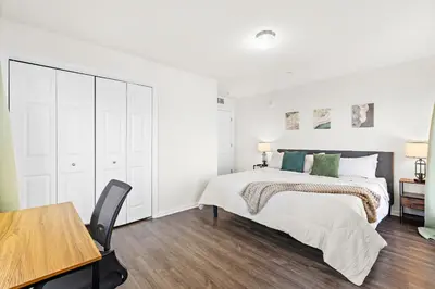 a white bedroom with a bed and a table at Urban Haven XL - NYC & Newark with free parking in Newark