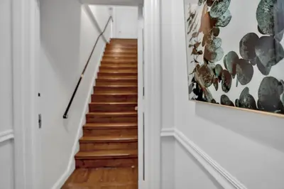 a staircase in a home with white walls and wood floors at Renovated 2BR in Germantown in Philadelphia
