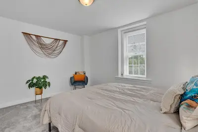 a white bedroom with a bed and a window at Renovated 2BR in Germantown in Philadelphia