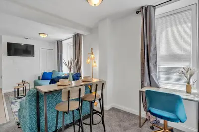 a living room with a table and blue chairs at Renovated 2BR in Germantown in Philadelphia