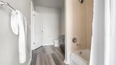 a white bathroom with a tub and a toilet at Landing Amazing 1BD Gym Game Room in Bayonne
