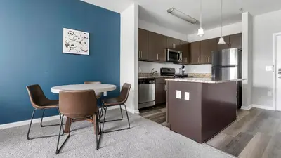 a kitchen with a table and chairs in a room at Landing Amazing 1BD Gym Game Room in Bayonne