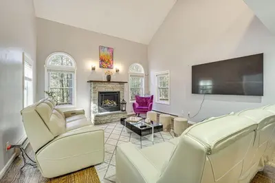 a living room with white furniture and a flat screen tv at Pocono Pride in East Stroudsburg