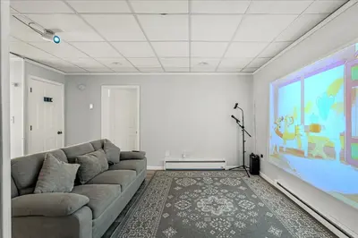 a living room with a couch and a large screen at Pocono Pride in East Stroudsburg