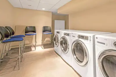 a laundry room with washing machines and stools at Club Wyndham Midtown 45 in New York