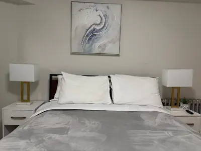 a bedroom with a large bed with two lamps at New York Central Park Suites in New York