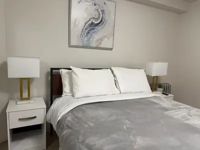 a bedroom with a bed with two night stands and two lamps at New York Central Park Suites in New York
