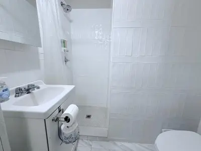 a white bathroom with a sink and a toilet at New York Central Park Suites in New York