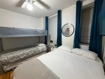 a bedroom with two bunk beds and a mirror at New York Central Park Suites in New York