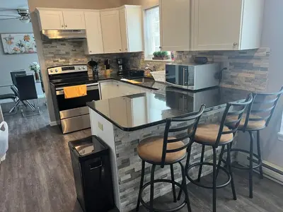 a kitchen with a counter and bar stools at Home in Poconos in Albrightsville
