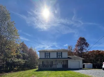 a white house with the sun in the sky at Home in Poconos in Albrightsville