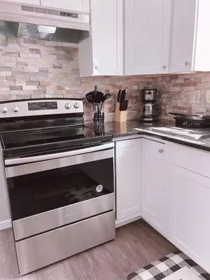 a kitchen with a stainless steel stove and white cabinets at Home in Poconos in Albrightsville