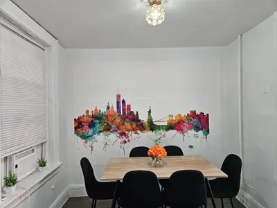 a dining room table with chairs and a painting on the wall at Renovated 3BR - Near Times Square - Family Groups in West New York