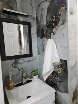a bathroom with a white sink and a mirror at Renovated 3BR - Near Times Square - Family Groups in West New York