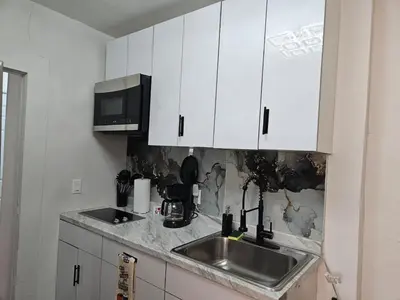 a kitchen with a sink and a microwave at Renovated 3BR - Near Times Square - Family Groups in West New York