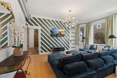 a living room with a blue couch and a striped wall at Oasis Spacious-Private Parking 16 Beds 29 Guests in Philadelphia