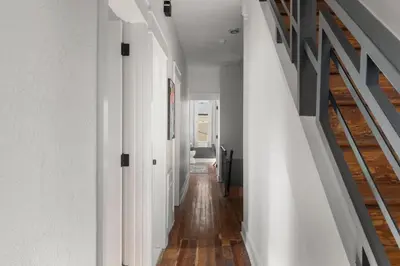an empty hallway with white walls and wood floors at Oasis Spacious-Private Parking 16 Beds 29 Guests in Philadelphia