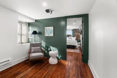 a living room with a chair and a bedroom at Oasis Spacious-Private Parking 16 Beds 29 Guests in Philadelphia