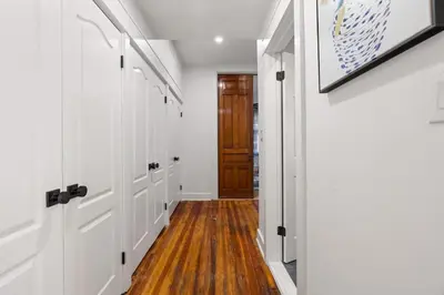 a hallway with white doors and wood flooring and a hallway with wood floors at Oasis Spacious-Private Parking 16 Beds 29 Guests in Philadelphia