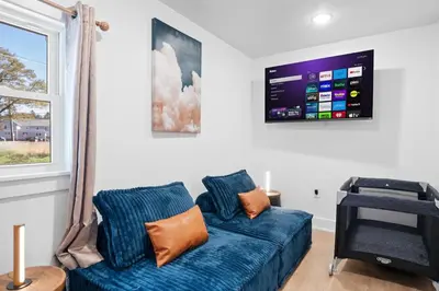 a living room with a blue couch and a flat screen tv at Summit Stay Near Kalahari & Raceway in Pocono Summit
