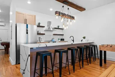 a kitchen with a bar with black stools at Summit Stay Near Kalahari & Raceway in Pocono Summit