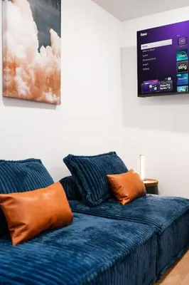 a blue couch with orange pillows in a room at Summit Stay Near Kalahari & Raceway in Pocono Summit