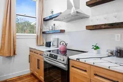 a kitchen with a stove with a pink tea kettle on it at Summit Haus Cozy Getaway in the Poconos in Pocono Summit