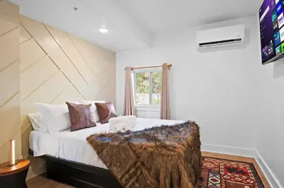 a bedroom with a large bed with a wooden headboard at Summit Haus Cozy Getaway in the Poconos in Pocono Summit
