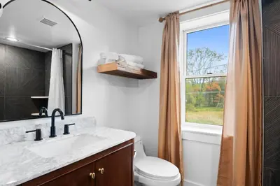 a bathroom with a sink and a toilet and a window at Summit Woods Hideaway Cozy Pocono Getaway in Pocono Summit