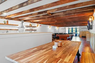 a dining room with a wooden table and a bar at Lakeside Serenity Retreat Near Kalahari Resort in Pocono Summit